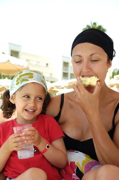 Healthy family. Mother and child eating apple and drinking water