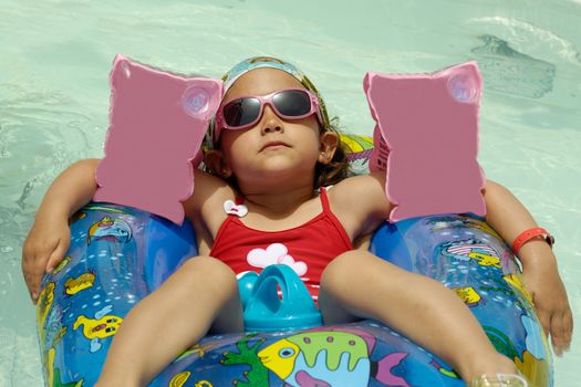 Young child is relaxing in pool.