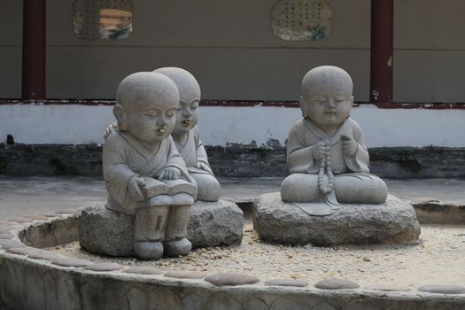 Little monks with peanuts in their mouths in a Chinese Buddhist temple.