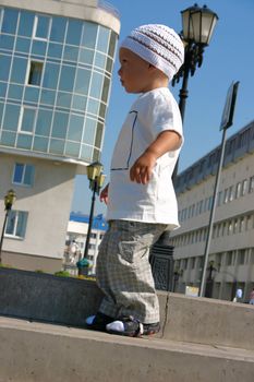 little boy in casual clothes on a walk by a sun summer day