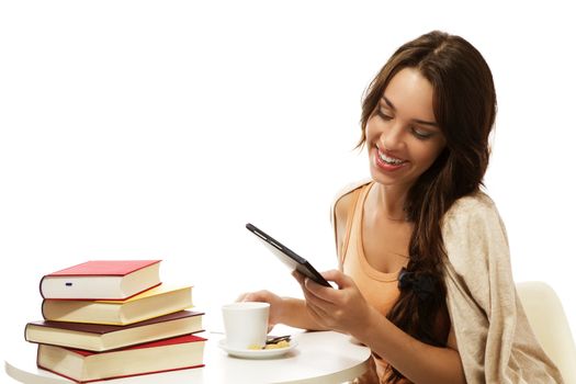 happy young woman reading ebook near books on white background
