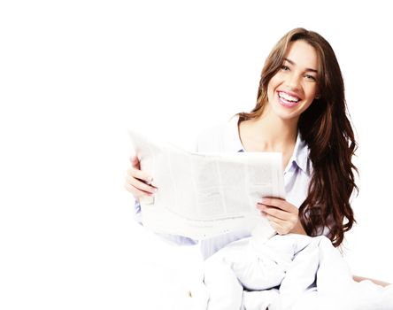 happy woman in bed with a newspaper on white background