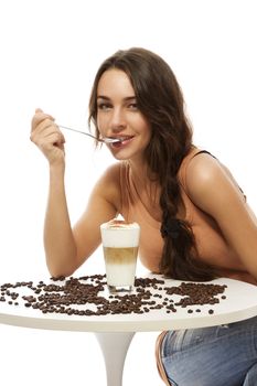 beautiful happy woman at a table with latte macchiato on white background