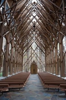 The center aisle of a wooden and glass church