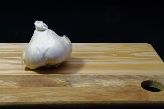 Whole garlic bulb on a wooden tray
