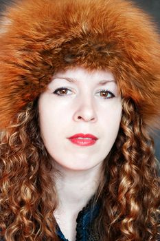 Beautiful young woman posing in big russian style fur hat