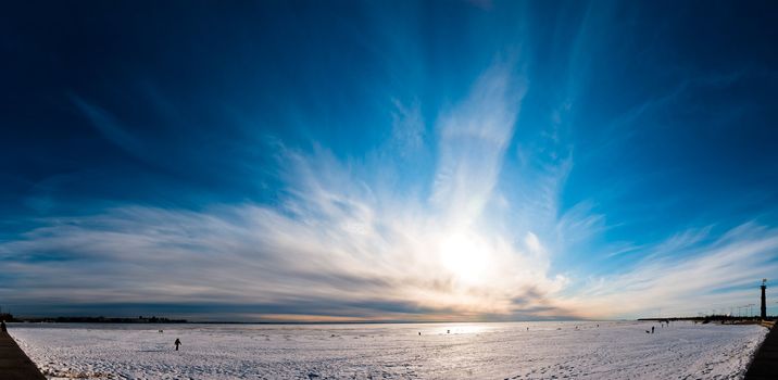 Beautiful cloudy and blue sky panorama over ice lake in Saint-Petersburg, Russia