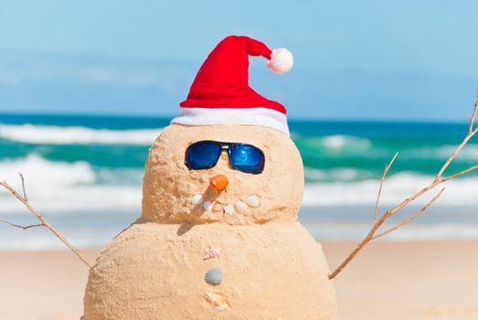 Snowman On Beach with shells as mouth and sun glasses