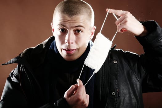 A young man with a protective mask on brown background