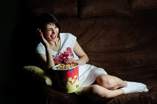 An image of a girl on a sofa laughing