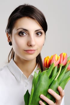 A young woman holding a bunch of orange tulips