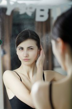 An image of a woman looking at herself in the mirror