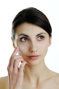 An image of a girl putting some cream onto her face