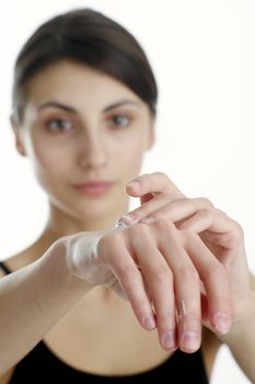 An image of a woman putting cream onto her hand