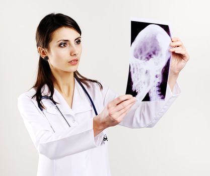 An image of female doctor examing x-ray of scull