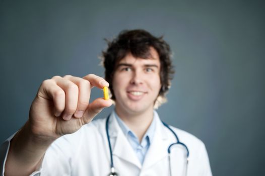 An image of a young doctor with a pill in his hand