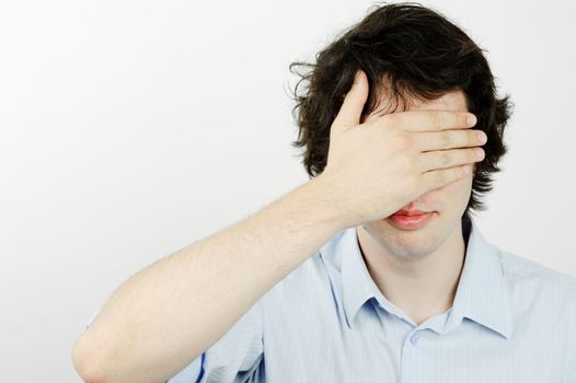 An image of a young man with his hand on his eyes