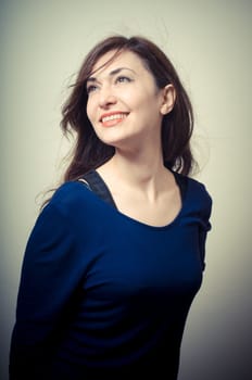 portrait of beautiful girl with long hair and blue sweater on gray background