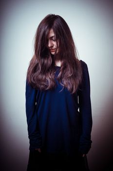 serious woman with long hair on vignetting background