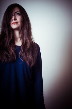 serious woman with long hair on vignetting background