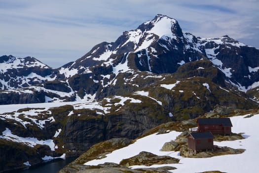 Picturesque mountain peaks on norwegian Lofoten islands covered in snow during summer