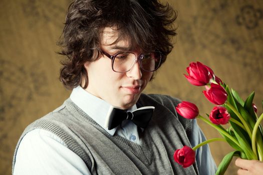 A young man in glasses and red tulips