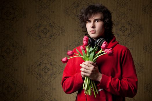 A young man with a bunch of red tulips