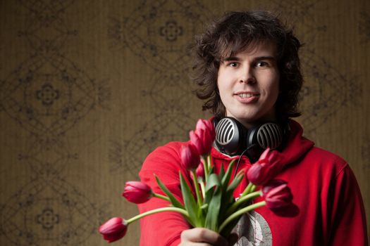 An image of a young man with red flowers