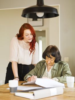 Young woman helping her Grandmother with paperwork