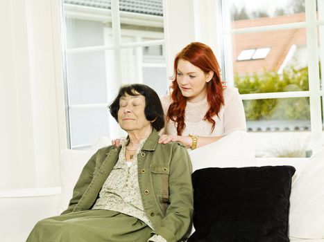 Young woman giving massage to her Grandmother