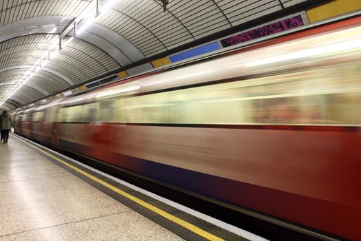 Subway train in motion arriving at a   underground train station. 