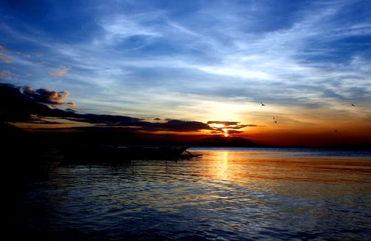 Beautiful sunset at the bay reflected in calm waters