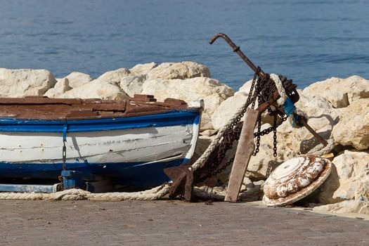 Old wooden boat, rusty anchor, chain and ropes