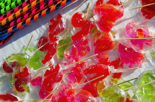 Various forms and colors sucked lollipops sold outside street fair market. Sweets.