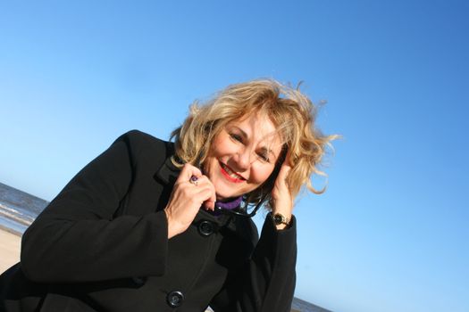 Portrait of a mature woman enjoying the sunlight on a beach.