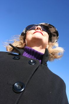 Portrait of a mature woman enjoying the sunlight on a beach.