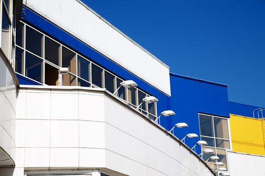 facade of modern building in blue and white tones on a background bright sky