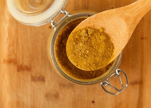 mixture spice in a wooden spoon, closeup