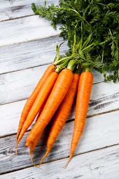 a fresh bunch of carrots on wood background