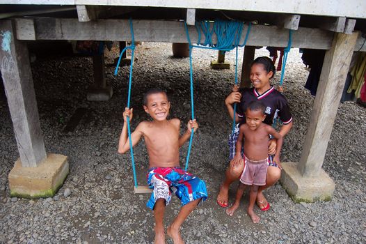 Kids are playing under their house, Mareguina, Papua New Guinea