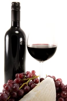 Picture of a bottle of red wine and some brie and a bunch of grapes