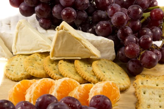 Picture of some grapes brie and some clementins and some cheese