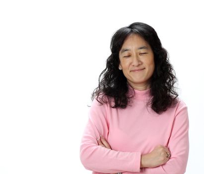 A Beautiful Asian woman Smiles While Thinking Happy Thoughts With Her Eyes Closed