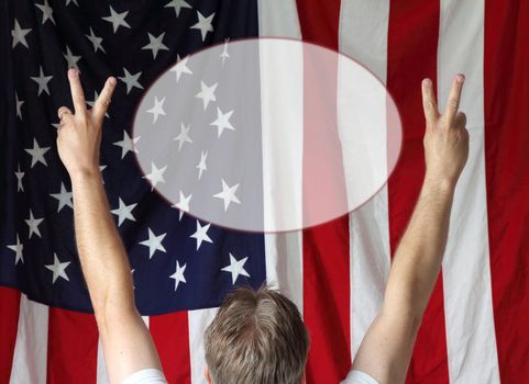 A man displays the peace sign toward the American flag