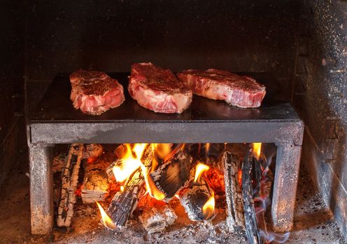 pork steaks preparing on the on a stone plate grill