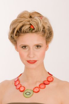 Attractive blonde young woman with strawberry-kiwi-chain