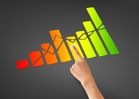 Hand pointing at a colorful business financial graph.