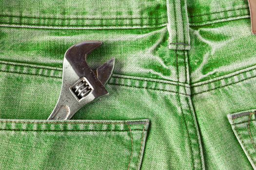 Green jeans pocket with old tool