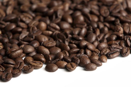 Roasted coffee beans on white background. Shallow depth of field