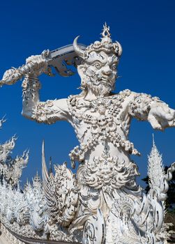 sculpture soldier guards the entrance to the White temple in Chiang Mai, Thailand
